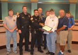 American Legion officials Bill Overby, Richard Plummer, Judie Madden, Tom Hernandez, Paul Zenz, and Mitch Grundenbreker join Chief Darrell Smith in awarding Sgt. Danny Santos 2016 Police Officer of the Year Award.